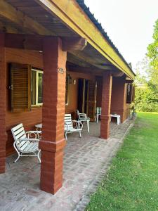 un porche d'une maison avec des chaises et une table dans l'établissement Casa Quinta Chascomús, à Chascomús