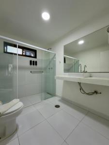 a bathroom with a glass shower and a toilet at Pousada Larimor in Boicucanga