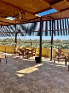 einen Pavillon mit Tischen und Stühlen auf einer Terrasse in der Unterkunft RAAK HOTEL فندق راك in Siwa + 40 Fotos