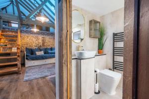 een badkamer met een wastafel, een toilet en een bank bij Homestead and Black Cat Barn in Northrepps +49 foto's