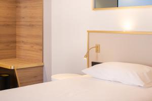 Giường trong phòng chung tại Brit Hotel Cahors - Le Valentré