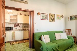 een groene bank in een woonkamer met een keuken bij Casa nella campagna Toscana in Lazzeretto +13 foto's