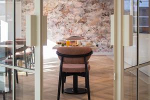 a bar with a stool with a tray of food at Brit Hotel Cahors Centre - Le Valentre in Cahors