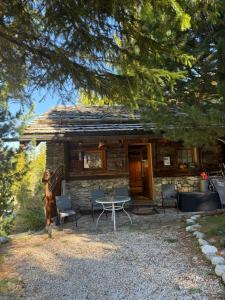 een blokhut met een tafel en stoelen ervoor bij Chalet Les Epilobes, Zinal in Zinal