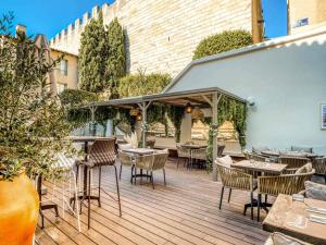 an outdoor patio with tables and chairs at Mercure Pont d’Avignon Centre in Avignon