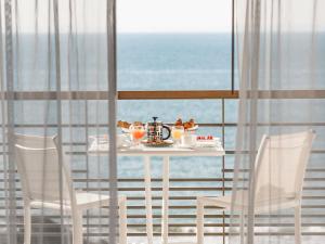 a table with a plate of food on it next to the ocean at Sofitel Quiberon Thalassa sea & spa in Quiberon