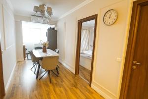 a dining room with a table and a clock on the wall at Mid Velvet Apartment, Free Parking, Self Check-in in Oradea +40 photos