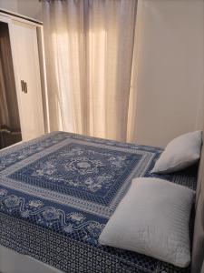 een bed met een blauw-wit tapijt erop bij mariam Garden in Al Aqālitah