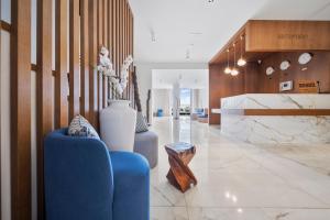 een lobby met een blauwe bank en een vaas bij HVD Nympha Hotel - Adults Only - Private Beach & Free Parking in Goudstrand