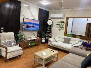 a living room with white furniture and a tv at Luxury Apartments - Downtown Cairo in Cairo +5 photos