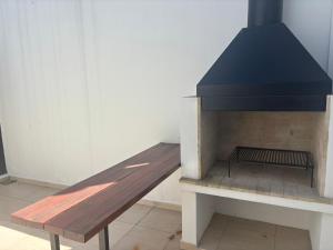 een houten bank voor een open haard bij Patios de City Bell Hotel and Apartments in City Bell