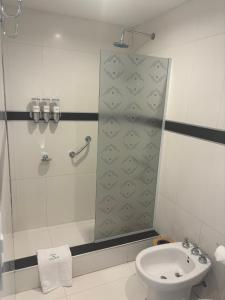 een badkamer met een douche, een toilet en een wastafel bij Patios de City Bell Hotel and Apartments in City Bell