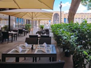 a restaurant with tables and chairs and umbrellas at Steigenberger Graf Zeppelin in Stuttgart