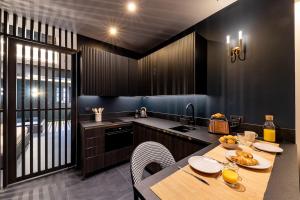 een keuken met een tafel, stoelen en een spoelbak bij Design apartment and contemporary experience in Vallauris