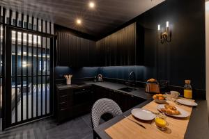 een keuken met een tafel, stoelen en een spoelbak bij Design apartment and contemporary experience in Vallauris