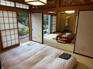 a bedroom with a large bed in a room with windows at 箱根宿燕帰 in Hakone
