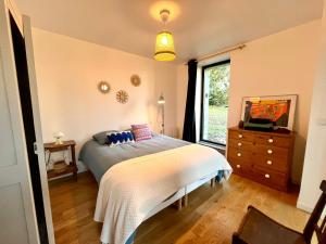 a bedroom with a bed and a dresser and a window at Bruisse in Les Iffs