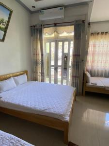 a bedroom with a bed and a window at Hotel Sơn Duyên in Ấp Thiện Lập +5 photos