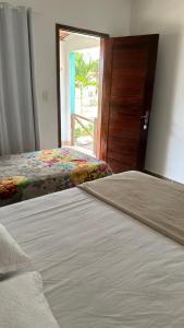 a bedroom with two beds and a door with a window at Pousada por do sol in Monte das Gameleiras +2 photos