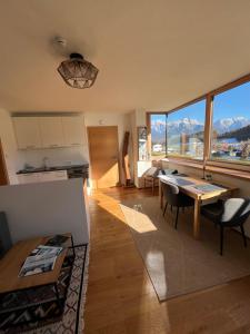 a kitchen and living room with a table and chairs at Apartment Steinernes Meer inklusive Saalfelden Leogang Card in Saalfelden am Steinernen Meer