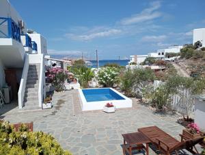 een patio met een zwembad en stoelen bij Aegean Star Hotel in Karavostasi