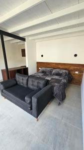 a black couch and a bed in a room at Las Loicas Chalten Apart in El Chalten