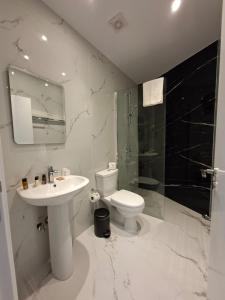 ein weißes Badezimmer mit Waschbecken und Toilette in der Unterkunft Twin Beds Standard Studios by Kentrikon 1924 Hotel, Old Town in Paphos City + 5 Fotos