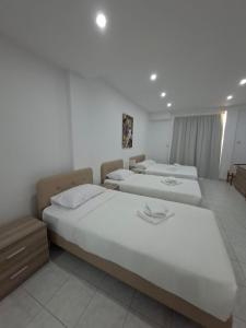 zwei Betten in einem Hotelzimmer mit weißen Wänden in der Unterkunft Twin Beds Standard Studios by Kentrikon 1924 Hotel, Old Town in Paphos City