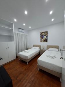 zwei Betten in einem Zimmer mit Holzboden in der Unterkunft Twin Beds Standard Studios by Kentrikon 1924 Hotel, Old Town in Paphos City