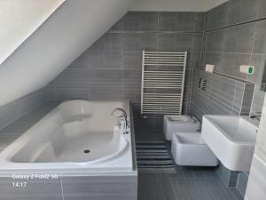 a bathroom with a tub and two sinks and a toilet at Ubytovna Kadaň in Kadaň +18 photos