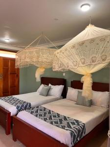 twee bedden in een kamer met bij Mufasha Boutique Suites in Kisoro