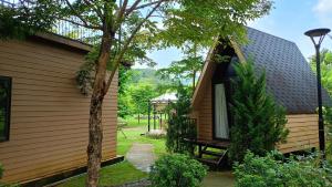 een zijaanzicht van een huis met een boom bij Cao Phong Glamping in Cao Phong