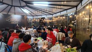 een groep mensen die aan tafels in een restaurant zitten bij Cao Phong Glamping in Cao Phong