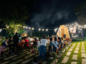 een menigte mensen die 's nachts aan tafel zitten bij Cao Phong Glamping in Cao Phong