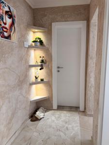 a hallway with a white door and a wall with shelves at Apartman Andrea in Brčko +4 photos