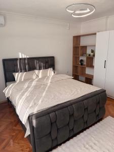 a bedroom with a large bed with a black headboard at Apartman Andrea in Brčko