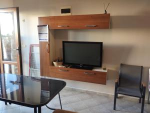 un salon avec une télévision à écran plat sur un mur dans l'établissement Paradise, à Bourgas