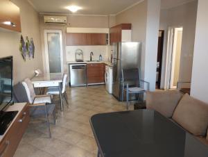 une cuisine avec une table, des chaises et un réfrigérateur dans l'établissement Paradise, à Bourgas