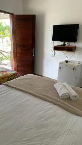 a bedroom with a bed with two towels on it at Pousada por do sol in Monte das Gameleiras
