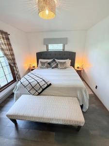 een slaapkamer met een groot bed en een bank. bij Laurel Thicket Cottage in Newland