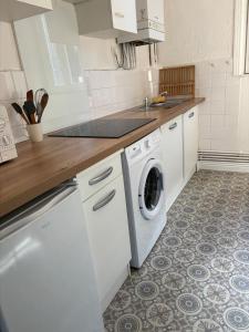 een keuken met een wasmachine en een wastafel bij Soleil urbain in Périgueux +17 foto's
