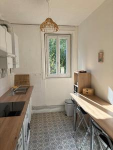 een keuken met een aanrecht en een raam erin bij Soleil urbain in Périgueux