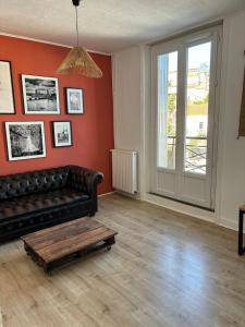 een woonkamer met een bank en een salontafel bij Soleil urbain in Périgueux