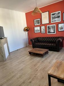 een woonkamer met een leren bank en een tafel bij Soleil urbain in Périgueux