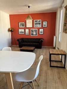 een woonkamer met een witte tafel en een rode muur bij Soleil urbain in Périgueux