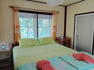 a bedroom with a bed and a large window at Koh Kood Little Hut in Ko Kood
