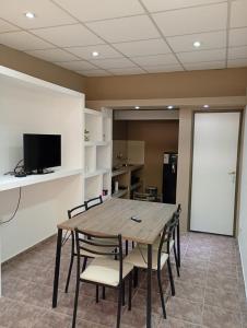 una sala conferenze con tavolo e sedie in legno di Alojamiento Gral Alvear a General Alvear