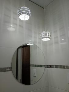 uno specchio in un bagno con due luci di Alojamiento Gral Alvear a General Alvear Altre 17 foto