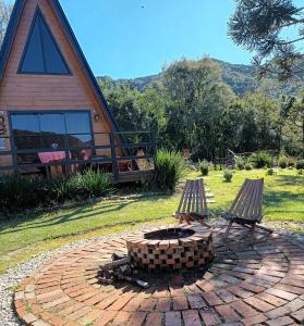 a fire pit in a yard next to a house at Chalé Aconchego Alfredo Wagner in Alfredo Wagner