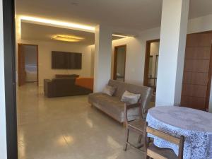 a living room with a couch and a table at Casa MarSol in Piúma